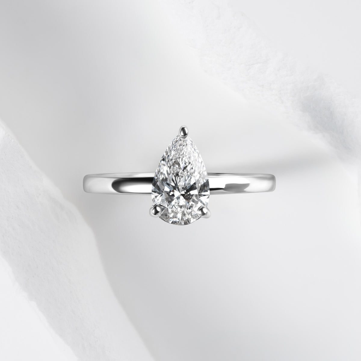 A platinum band with a pear cut solitaire laboratory grown diamond.