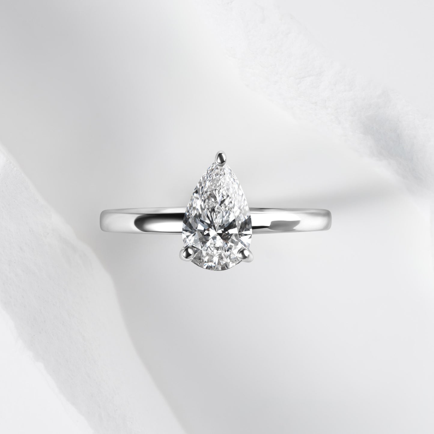 A platinum band with a pear cut solitaire laboratory grown diamond.