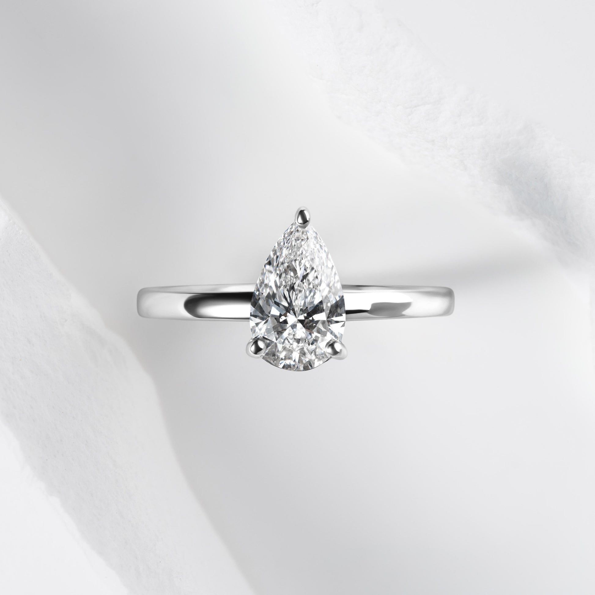 A platinum band with a pear cut solitaire laboratory grown diamond.