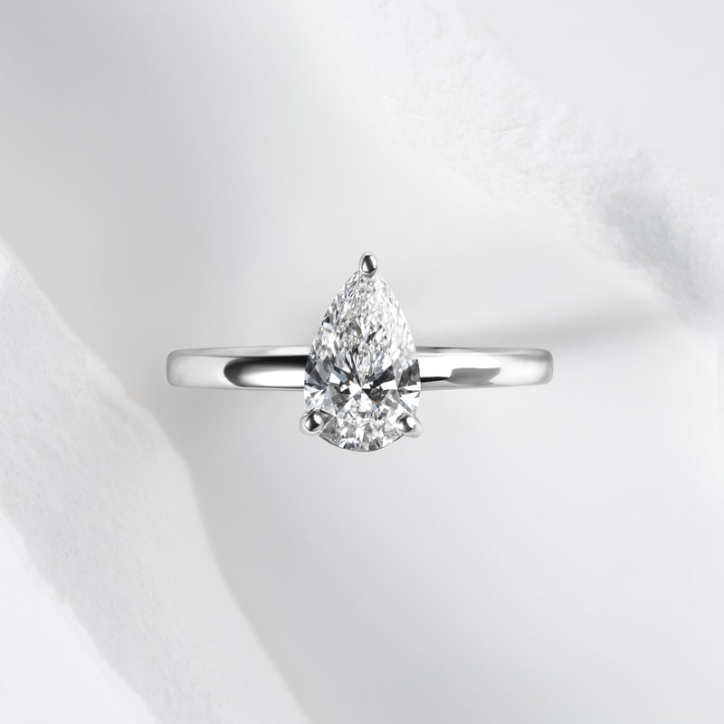 A platinum band with a pear cut solitaire laboratory grown diamond.